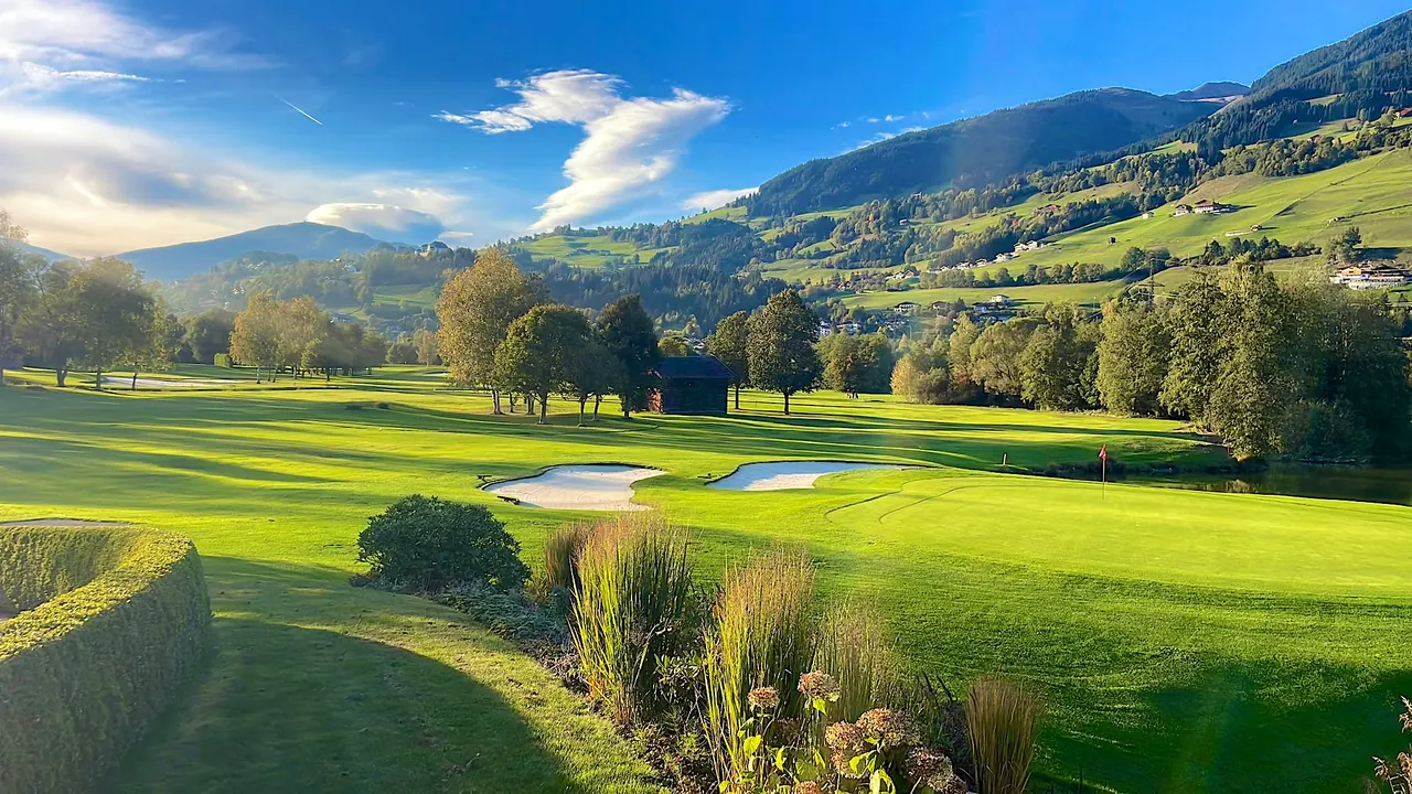 Green met bunkers en vijver in de avondzon, Golfclub Nationalpark in Mittersill